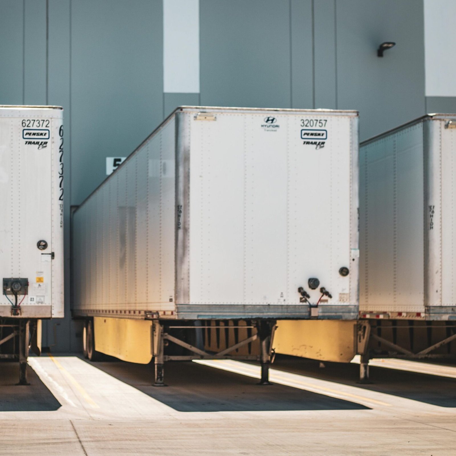 A row of freight trailers parked at a commercial loading dock, emphasizing transportation and logistics.